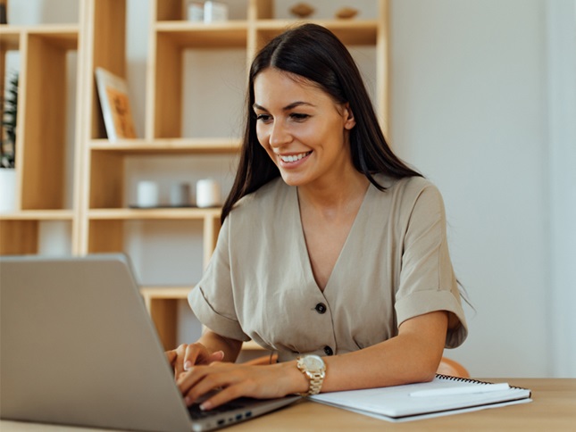 Smiling woman typing at her laptop