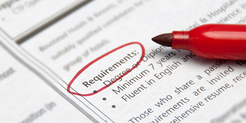 Red pen resting on document page, where the word "requirement" is circled in red.