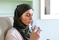 Young woman bringing oxygen breathing mask up to her face