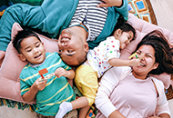 overhead view of Mom, Dad and two small children playing on the floor