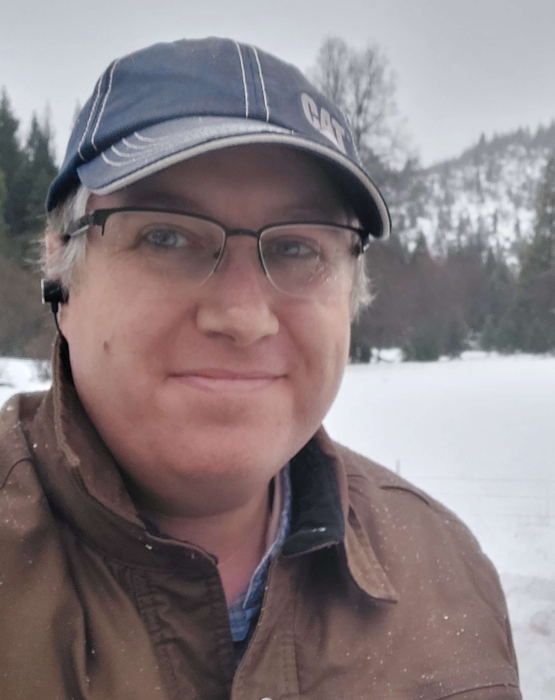 Jason Evans on an inspection in Siskiyou County. There is snow on the hill in the background.