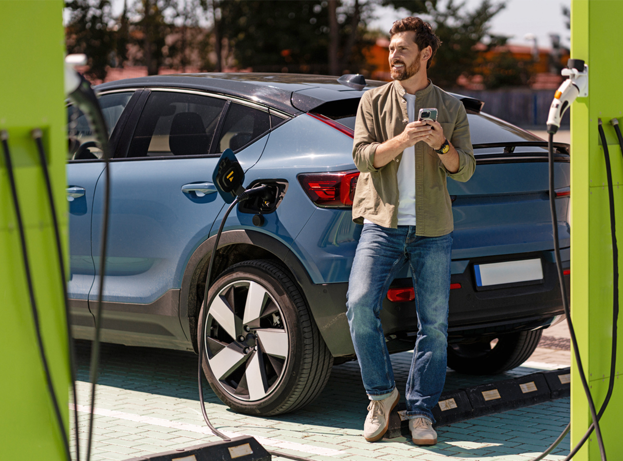 A rideshare driver plugs in an electric vehicle.