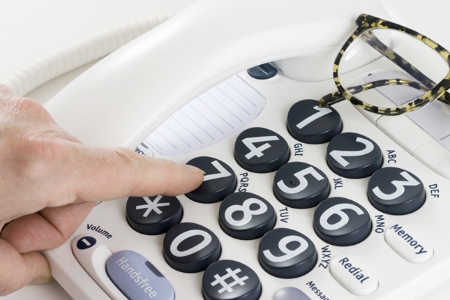 A person using a low-vision telephone dials
