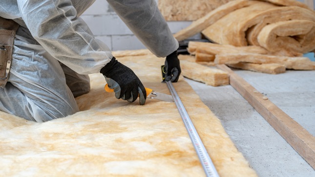A constructor laying down the thermal isolation on the floor